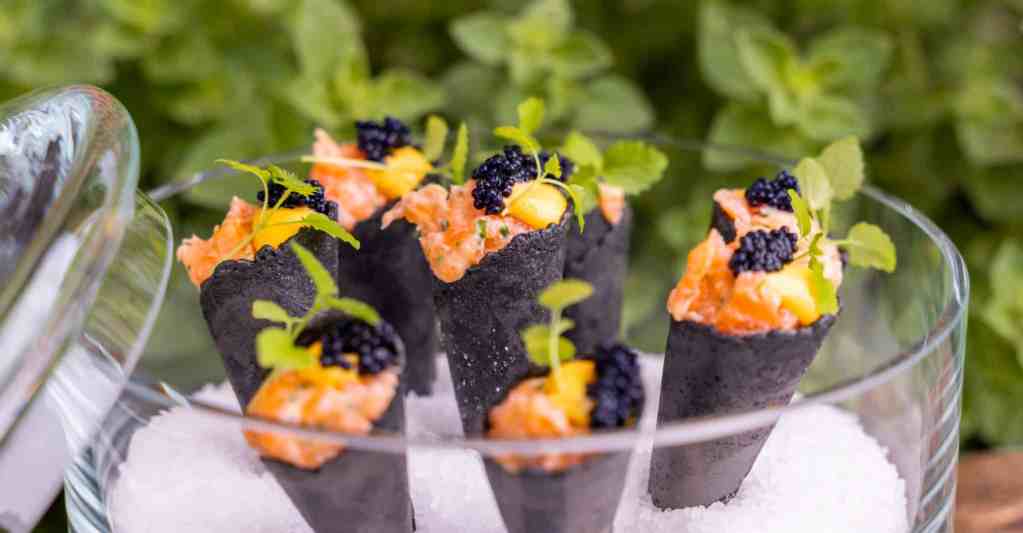 Foto van een heerlijke zwart hoorntje met zalm tartaar afgewerkt met huisbereide bieslook crème